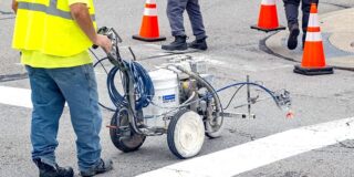 A close up of a line painting machine in a construction zone.