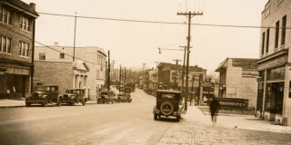 Sienna tinted old photo of a road with antique cars