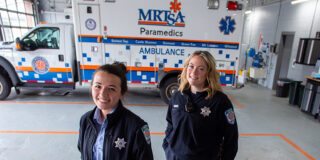 Two paramedics standing in front of a Medical Rescue Team South Authority ambulance