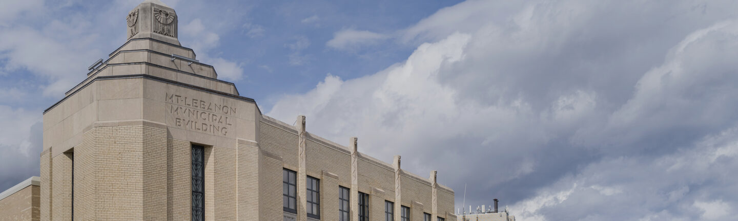 A closeup of the Mt. Lebanon Municipal building with a cloudy sky behind.