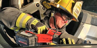 Firefighter using a power saw
