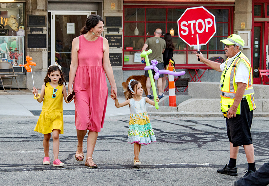 Crossing guard assisting woman and children