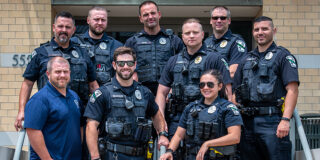 A group of police officers in uniform pose for a picture