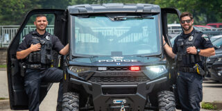 Two police officers stand with a ATV with 
