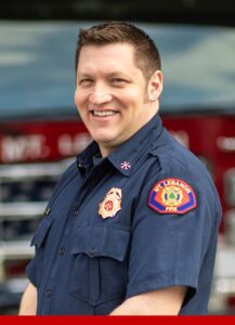 Deputy Chief Dan Morris portrait in front of a fire engine