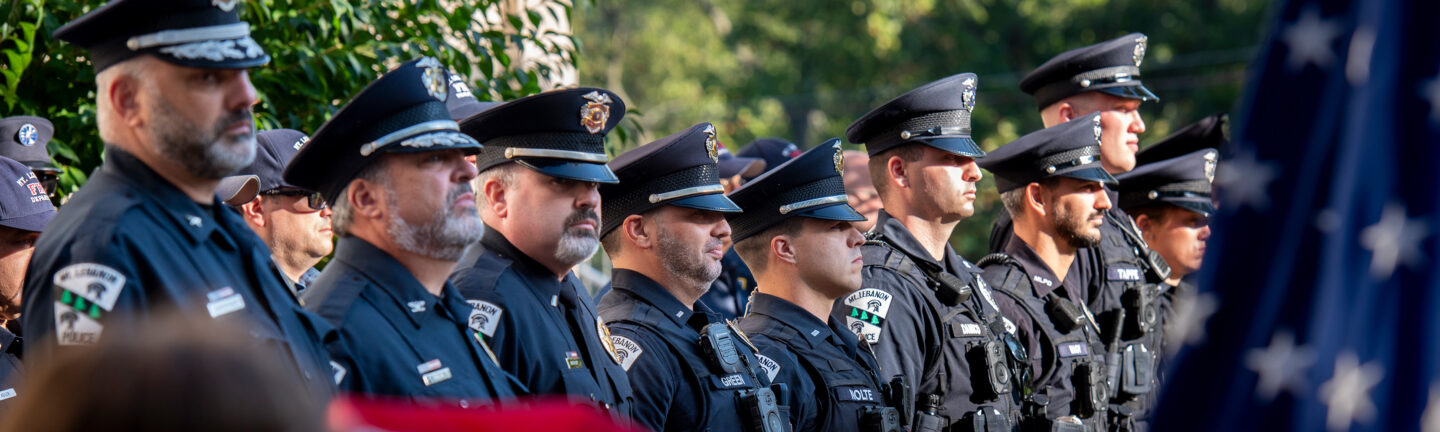 A line of police officers standing at attention dressed in full uniform.